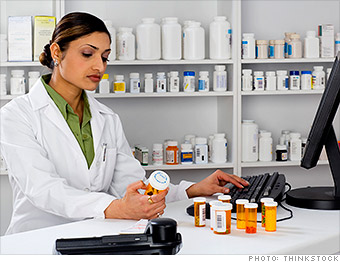 Pharmacist reading medication bottle