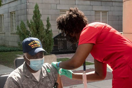 A Veteran receiving their flu shot outside of a VA facility 