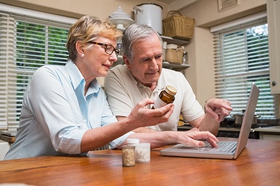 Couple looking up rx refill options at home 