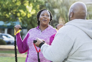 A Veteran and spouse exercising with resistance bands