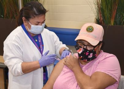 Female Veteran getting vaccinated