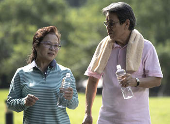 An older couple hydrating after working out